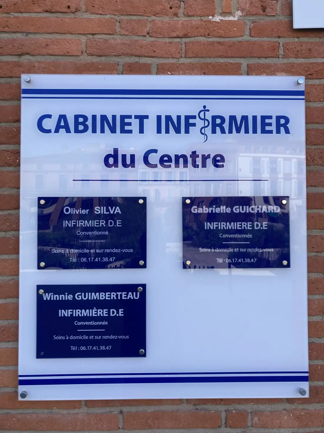 Plaque du Cabinet infirmier du Centre sur la façade en briques, avec les noms des infirmiers