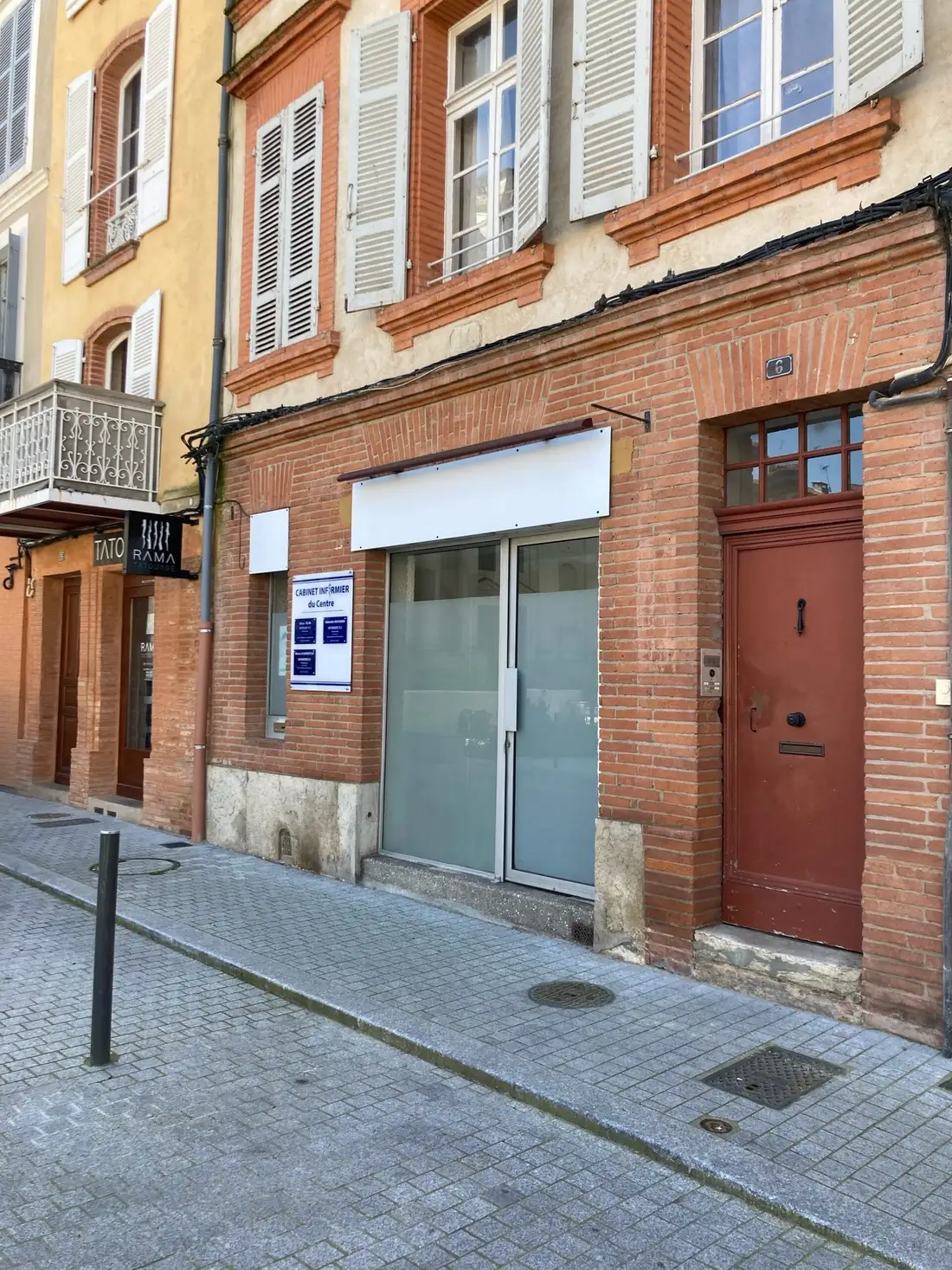Entrée du cabinet au rez-de-chaussée d’une façade en briques